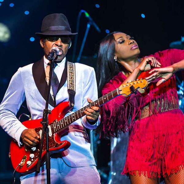 Ike im Anzug mit roter Gitarre singend mit tanzender Tina im rotem Kleid